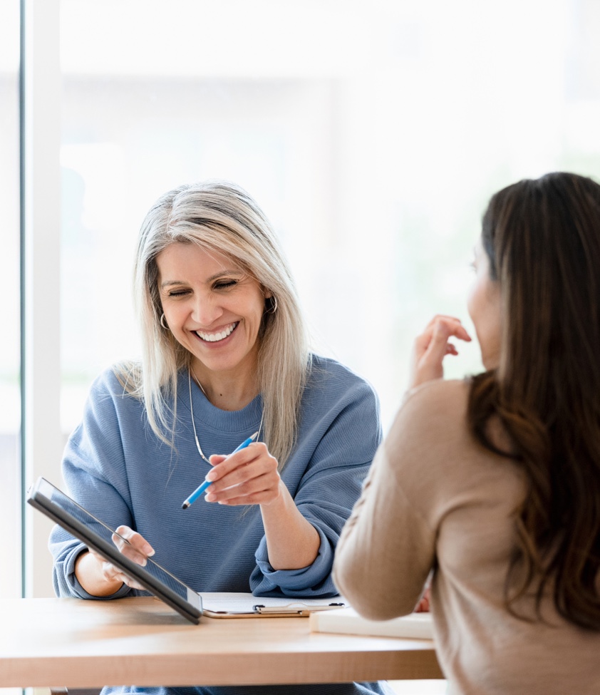 Female financial advisor reviews documents on digital tablet